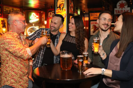 Gemischte Gruppe stößt im Pub in Egmond aan Zee zusammen mit Bier an