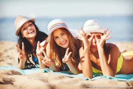 Drei Freundinnen liegen in Mallorca am Strand - Stockfoto